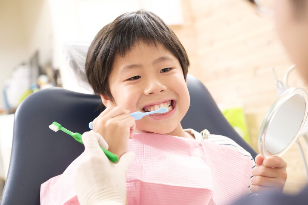 歯科医院で歯磨きを行う少年