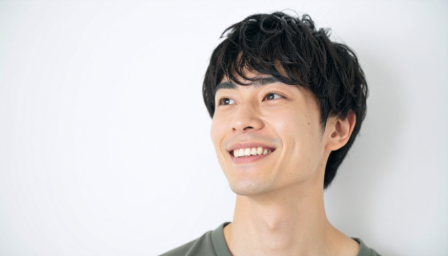 八重歯を矯正して綺麗な歯並びになった笑顔の男性