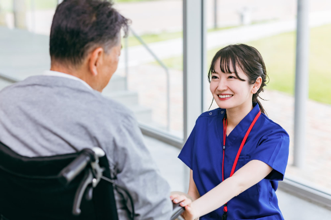 介護施設で車椅子の患者と話す歯科医