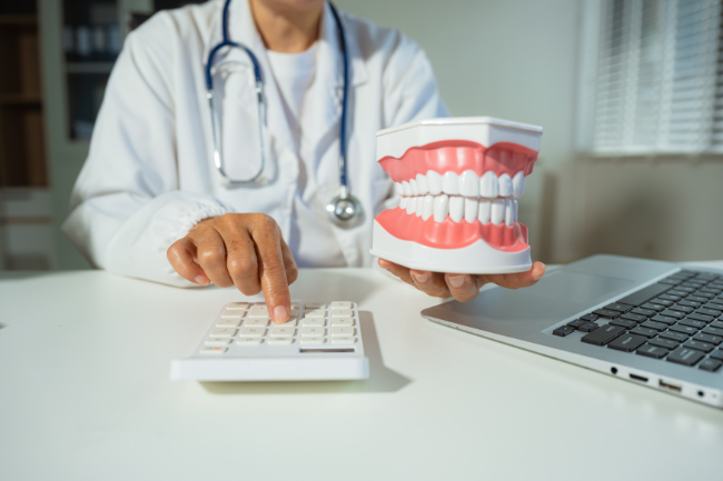 歯を削るのにかかる費用を計算する歯科医師