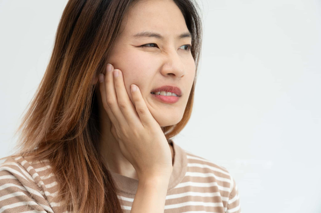 根管治療後に強い痛みを感じている女性