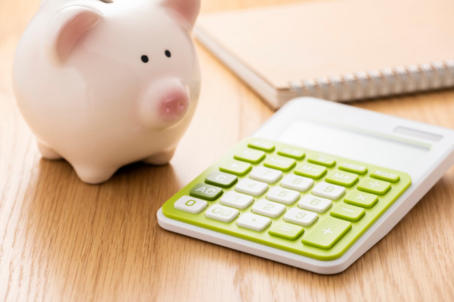 インビザライン・ファーストの治療にかかる費用を示す計算機と豚の貯金箱