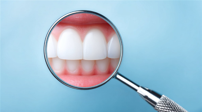 審美歯科できれいになった前歯を虫眼鏡で拡大しているイメージ