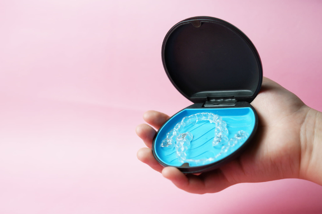 インビザライン・ファーストを持った子どもの手